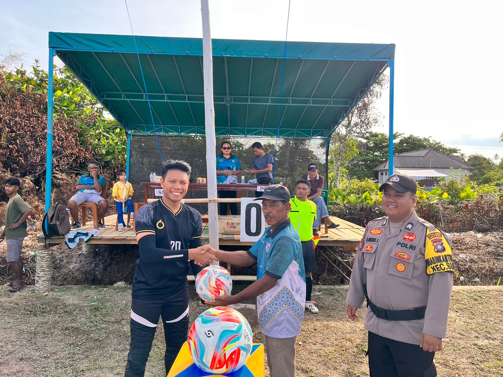 Kapolsek Serasan, Ipda Mazlan menyerahkan bantuan bola kaki